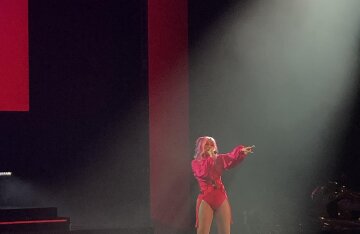 Cardi B performing at a concert with a microphone in hand