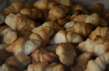A golden, flaky croissant pastry on a plate