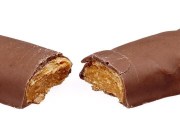 A Butterfinger candy bar broken in half showing its layered peanut-buttery center
