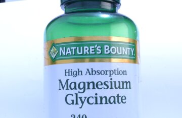 Pills of magnesium glycinate supplement on a surface