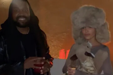 Bianca Censori in a fur hat and a plush toy and Kanye West at a party in Dubai