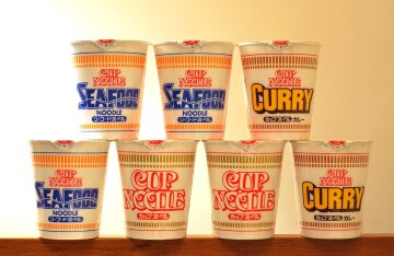 An open Cup Noodles instant ramen cup with chopsticks