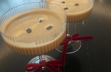 A dark chocolate-colored cocktail served in a martini glass