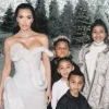 North West in Kanye West's Balmain jacket, Kim Kardashian in Mugler at a Christmas party