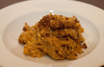 A baked pumpkin filled with cheesy ziti pasta in tomato sauce