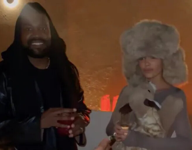 Bianca Censori in a fur hat and a plush toy and Kanye West at a party in Dubai