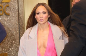 Jennifer Lopez in a pink dress with a deep neckline on the set of a TV show