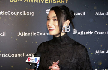 Dua Lipa seated during a VOA interview in 2021