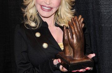 Dolly Parton smiling in a portrait at an awards ceremony
